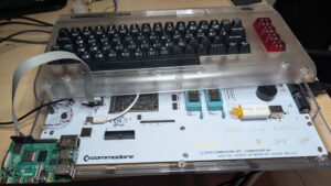 Bricked Commodore 64 Ultimate on a desk with a Raspberry Pi 4 and JTAG jumper wires connected to its P5 header.